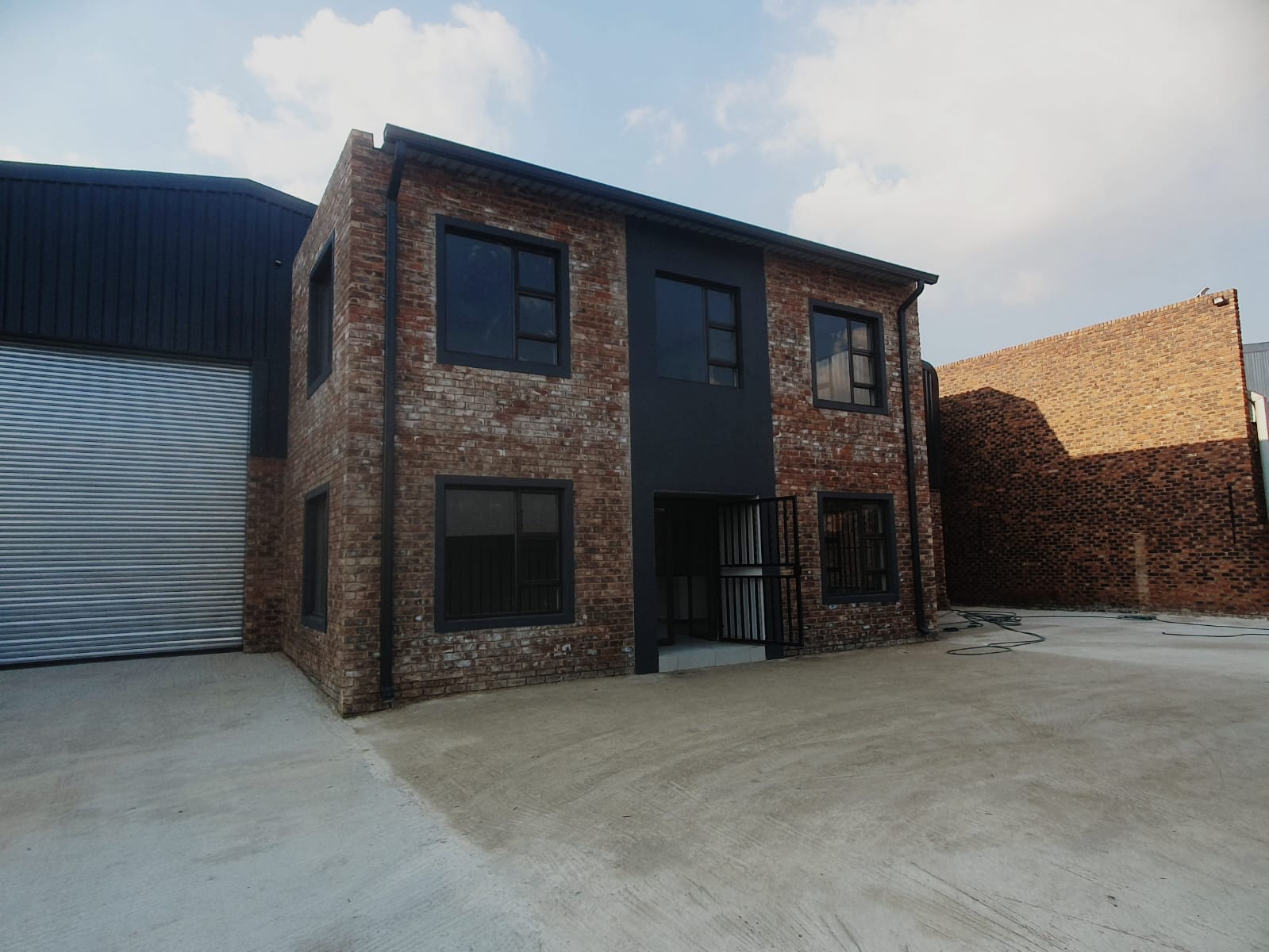 Black gutters and downpipes on a two storey brick and charcoal commercial building